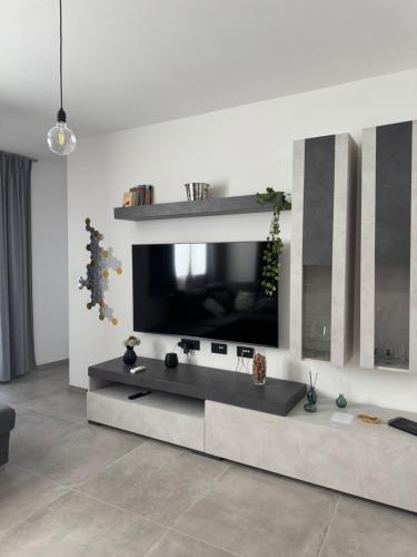 a living room with a flat screen tv on a wall at Domus Aura Apartments in SantʼAntìoco
