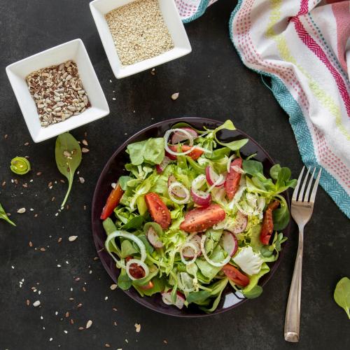 a salad in a bowl on a table with a fork at Le Torri - Castiglione Falletto in Castiglione Falletto