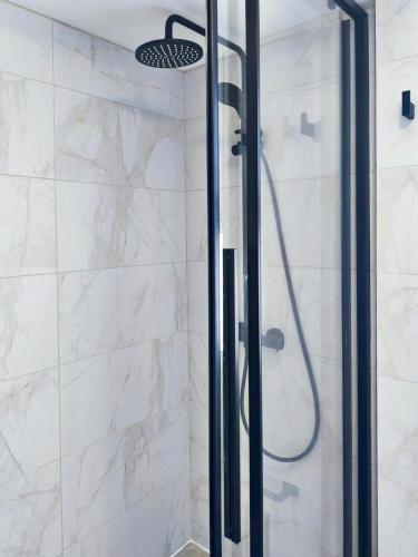 a shower with a glass door in a bathroom at Joyscape beachfront residence in Larnaca