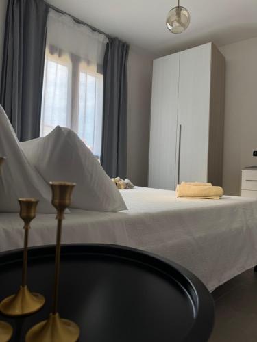 a bedroom with a bed with white sheets and a window at Domus Aura Apartments in SantʼAntìoco