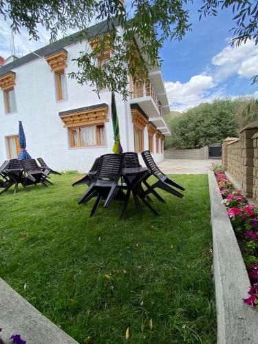 a group of picnic tables in front of a building at Tsanavilla guest house in ladakh