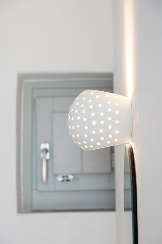 a mirror with a polka dot light on a door at AetherOia Suites in Oia