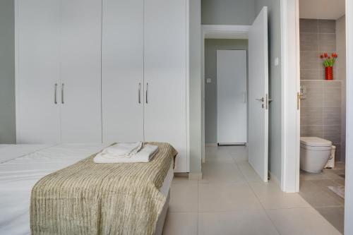 a white room with a bed and a toilet at Majestic Sunset Salt Lake Views 300m From Beach in Larnaka