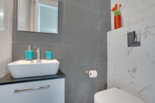 a bathroom with a white sink and a toilet at Majestic Sunset Salt Lake Views 300m From Beach in Larnaka
