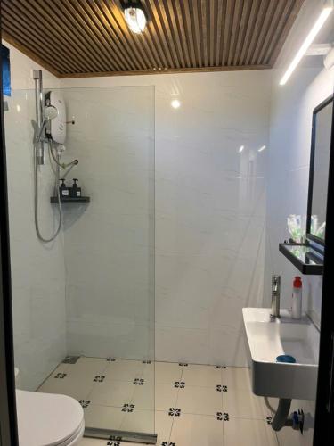 a bathroom with a shower and a toilet and a sink at Nguyen Shack Retreat Resort in Phong Nha