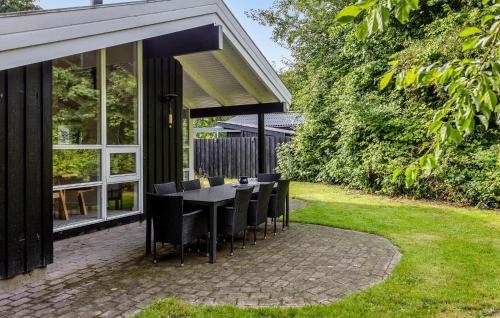 a dining table and chairs on a patio at Holiday Home Gyldenrisvej Denm in Skattebølle