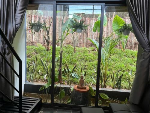 a window with a view of a garden outside at Nguyen Shack Retreat Resort in Phong Nha