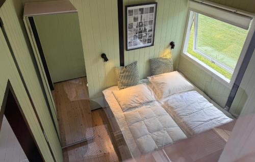 a small bedroom with a bed and a window at Holiday Home Jacobslystvej Gilleleje Xi in Gilleleje