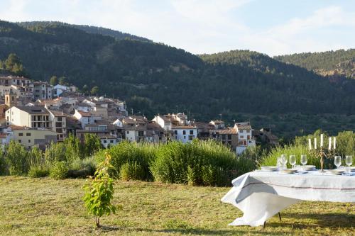 a table in a field with a town in the background at La Casa de Los Moyas in Olba