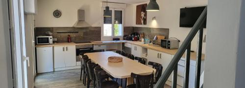 une cuisine avec une table et quelques chaises dans l'établissement Grande OU petite maison sur 360m2 de jardin clos sans vis à vis, à Gentilly