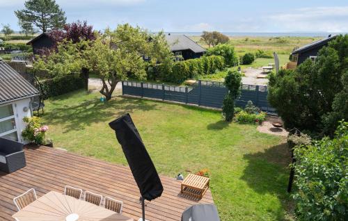 eine Luftaufnahme eines Hinterhofs mit einem Sonnenschirm und Stühlen in der Unterkunft Lovely Home In Faxe Ladeplads With Wifi in Fakse Ladeplads