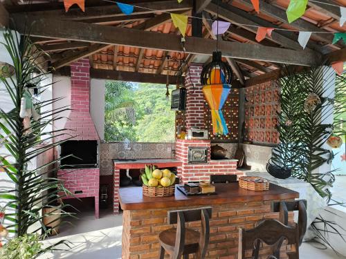 een patio met een tafel en een stenen open haard bij Fazenda Riachão in Pojuca