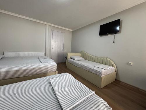 a room with two beds and a flat screen tv at Karo Hotel in K'obulet'i