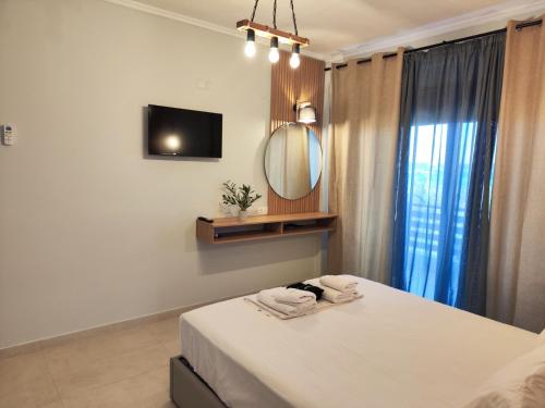a bedroom with a bed with a mirror and a tv at seaandolive in Ammouliani