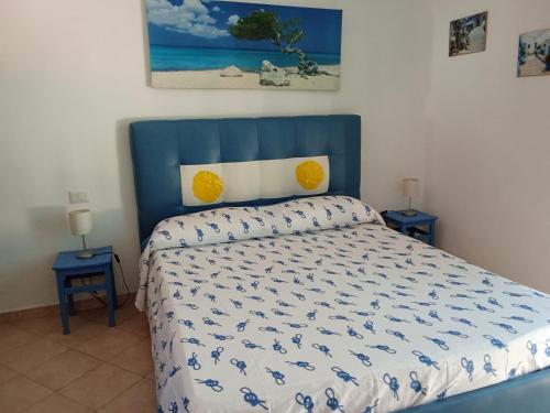 a bedroom with a bed with a blue headboard and two tables at Casa Vacanze Torre di Mola in Formia
