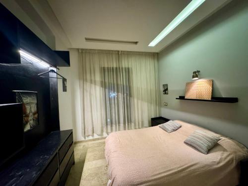 a bedroom with a bed and a large window at Appartement familial in Casablanca