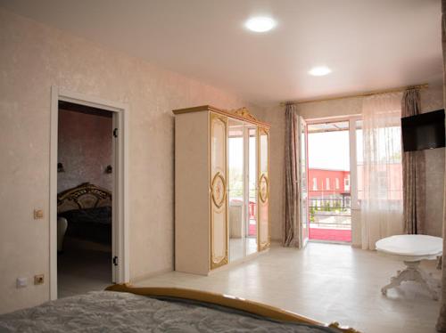 a bedroom with a bed and a large window at AMSTERDAM hotel&swimming pool in Suprunovka