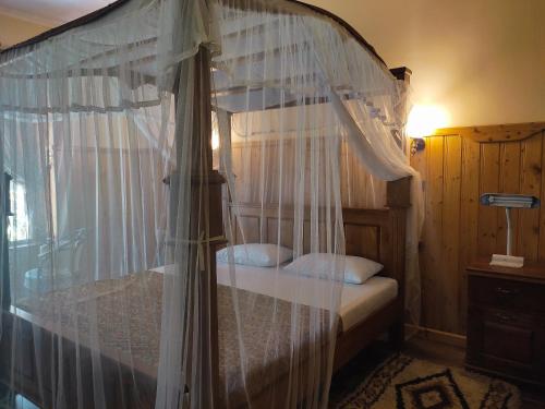 a bedroom with a canopy bed with white curtains at Secret Garden Villa Bandarawela in Bandarawela