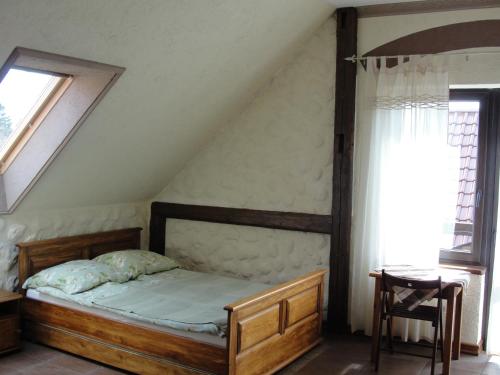 a bedroom with a wooden bed in a attic at Pokoje i domki Saraceńska Chata in Stegna