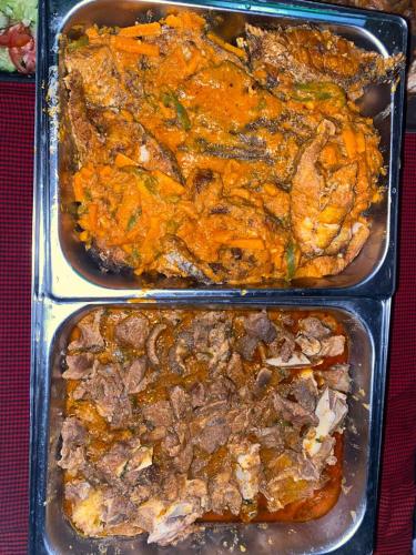 tre vassoi di metallo contenenti cibo con carne e verdure di Kili Spring Hotel ad Arusha