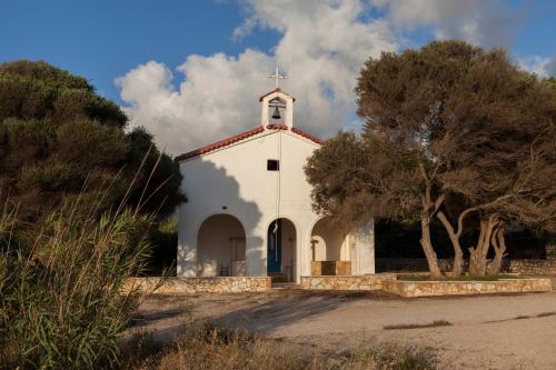 a small white church with a cross on top at Dialiskari Villas in Marathopolis