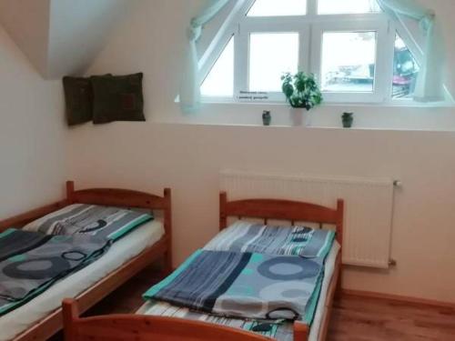 Dos camas individuales en una habitación con ventana. en Agroturystyka Sielskie Góry, en Duszniki-Zdrój