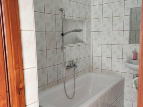 y baño de azulejos blancos con ducha y bañera. en Agroturystyka Sielskie Góry, en Duszniki-Zdrój
