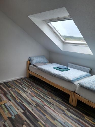 ein Schlafzimmer im Dachgeschoss mit zwei Betten und einem Fenster in der Unterkunft Fredi Apartment, moderne ruhige Wohnung, nur 4 km von der A2 in Leopoldshöhe