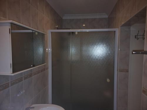 a shower with a glass door in a bathroom at Ojong's Guesthouse Ridgeworth - Bellville in Tyger Valley