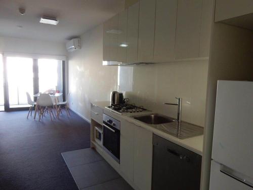 een keuken met een spoelbak en een fornuis bovenste oven bij Holiday Business Trip Family Trip or Business Trip Comfortable Entire Apartment in Springvale
