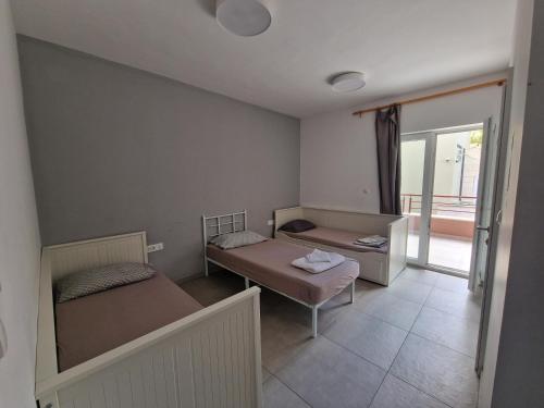 a small room with two beds and a balcony at SUBTUB Hostel Makarska in Makarska