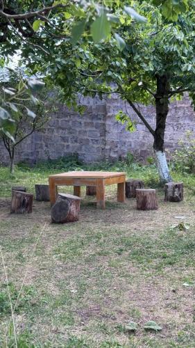 a wooden bench sitting under a tree in a park at Madoyans Rest House in Antarut