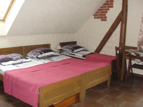 a bedroom with two beds with pink sheets at Pokoje i domki Saraceńska Chata in Stegna