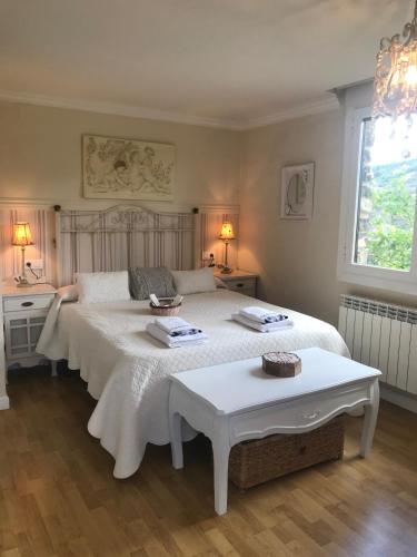 a bedroom with two beds and two tables in it at Casa el EDEN de Cameros in Laguna de Cameros