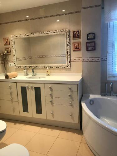 a bathroom with a sink and a tub and a mirror at Casa el EDEN de Cameros in Laguna de Cameros