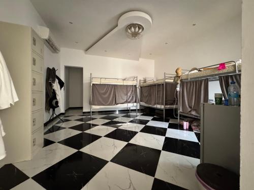 a room with a black and white checkered floor at Dar Shaden hostel in Muscat