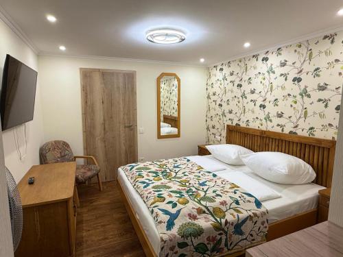 a bedroom with a bed with a floral wallpaper at Apartment am Tannenweg in Badenweiler