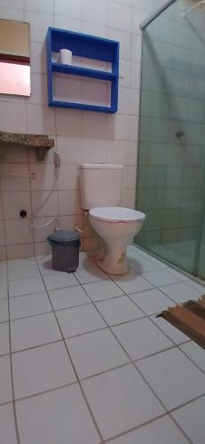 a bathroom with a toilet and a glass shower at Flat Casa Taiba 2001 in Taíba