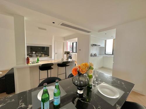 a kitchen and living room with a table and two bottles at Zhome Parkville-Three bedrooms with city view-Near Xin Tian Di in Shanghai
