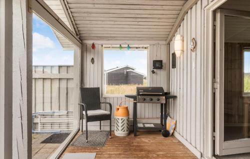 a screened in porch with a grill and a chair at 3 Bedroom Lovely Home In Harboøre in Harboør