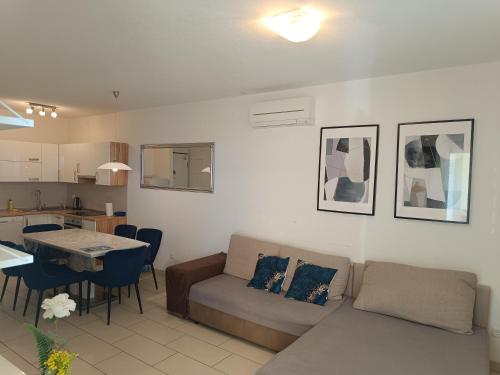 a living room with a couch and a table at Blue Light Apartman in Rogoznica
