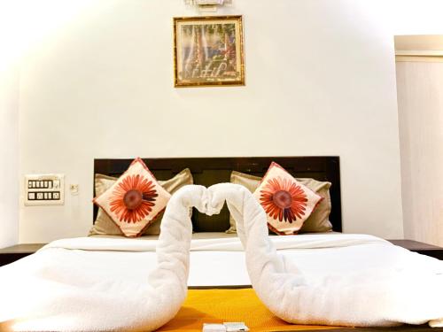 a bedroom with a bed with a swan shaped bed frame at Hotel Jasmine Paldi Ahmedabad in Ahmedabad