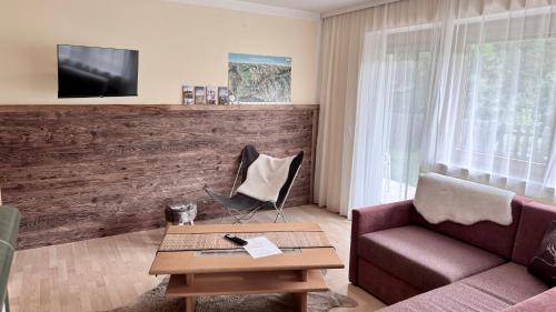 a living room with a couch and a table at Hollys Ferienwohnungen in Gerlos