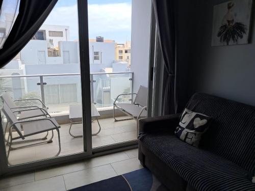 a living room with a couch and a balcony at Boavista Estoril Residence Sol & Mar in Sal Rei
