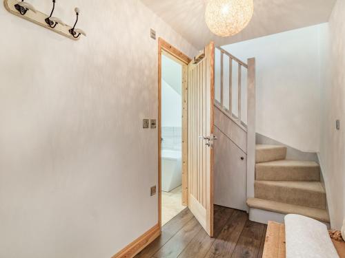 a hallway with stairs and a door leading into a room at Horseshoes House in Watton