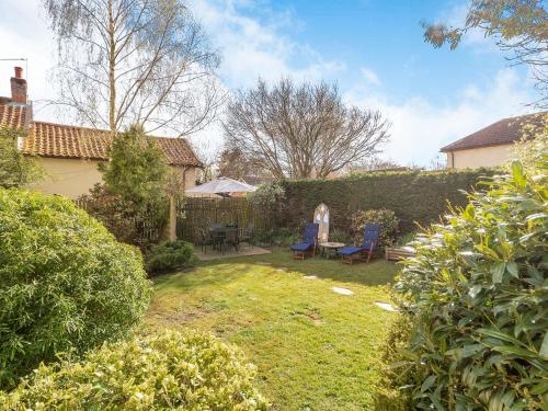 a garden with two chairs and a table in a yard at Horseshoes House in Watton