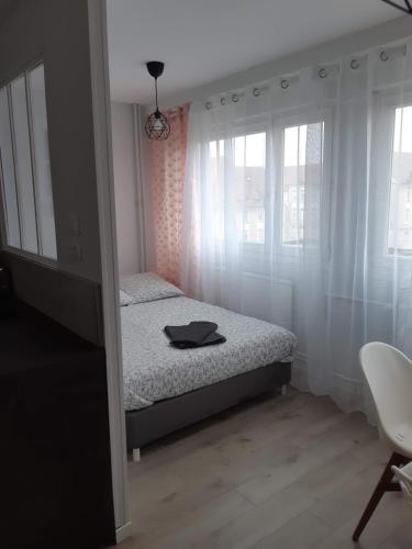 a bedroom with a bed and two windows at Gabcha in Metz