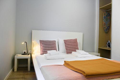 a bedroom with a white bed with two pillows at Apartamentos do Parque in Vila Real