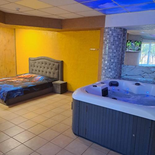 a room with a tub and a bed in it at Masažinis baseinas senamiestyje in Klaipėda