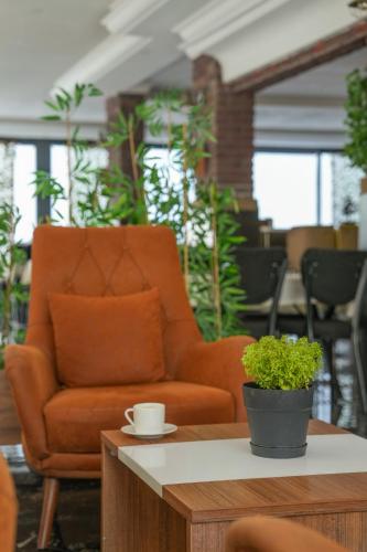 a living room with an orange chair and a coffee table at Bianco Beach Hotel in Kusadası